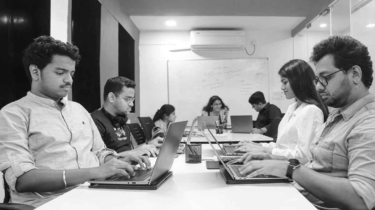 Strategy session — laptops, whiteboard, ideas in flight.
